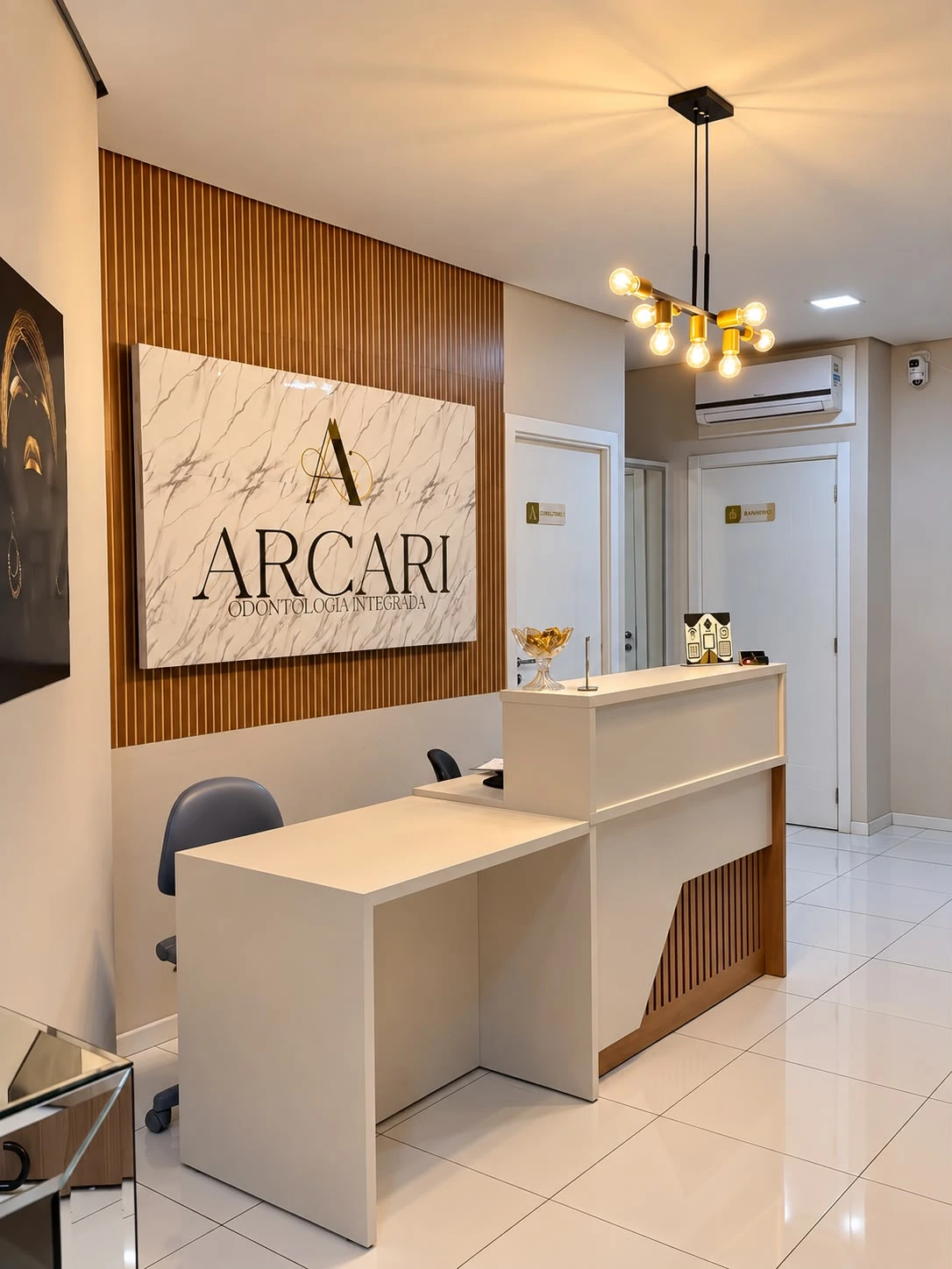 Recepção da Arcari Odontologia Integrada com o painel da marca